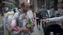 Seorang warga menanyakan kantung-kantung plastik berisi sampah-sampah pada tubuh Rob Greenfield di New York, AS, 4 September 2016. Aktivis lingkungan itu bertekad untuk memakai semua sampah yang ia hasilkan selama 30 hari. (AFP Photo/Bryan R. Smith)
