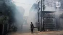 Petugas melakukan pengasapan atau fogging di kawasan perumahan Jalan Delima Raya, Jakarta Barat, Senin (25/10/2021). Pemyemprotan guna membasmi nyamuk Aedes aegypti yang menyebabkan penyakit demam berdarah (DBD) saat musim hujan di kawasan pemukiman warga. (Liputan6.com/Johan Tallo)