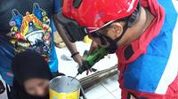 Aksi heroik petugas melepas kaleng biskuit yang nyangkut di kepala seorang anak jadi viral di media sosial. (dok. Instagram @humasjakfire/https://www.instagram.com/p/Cre3ogVJFgb/)