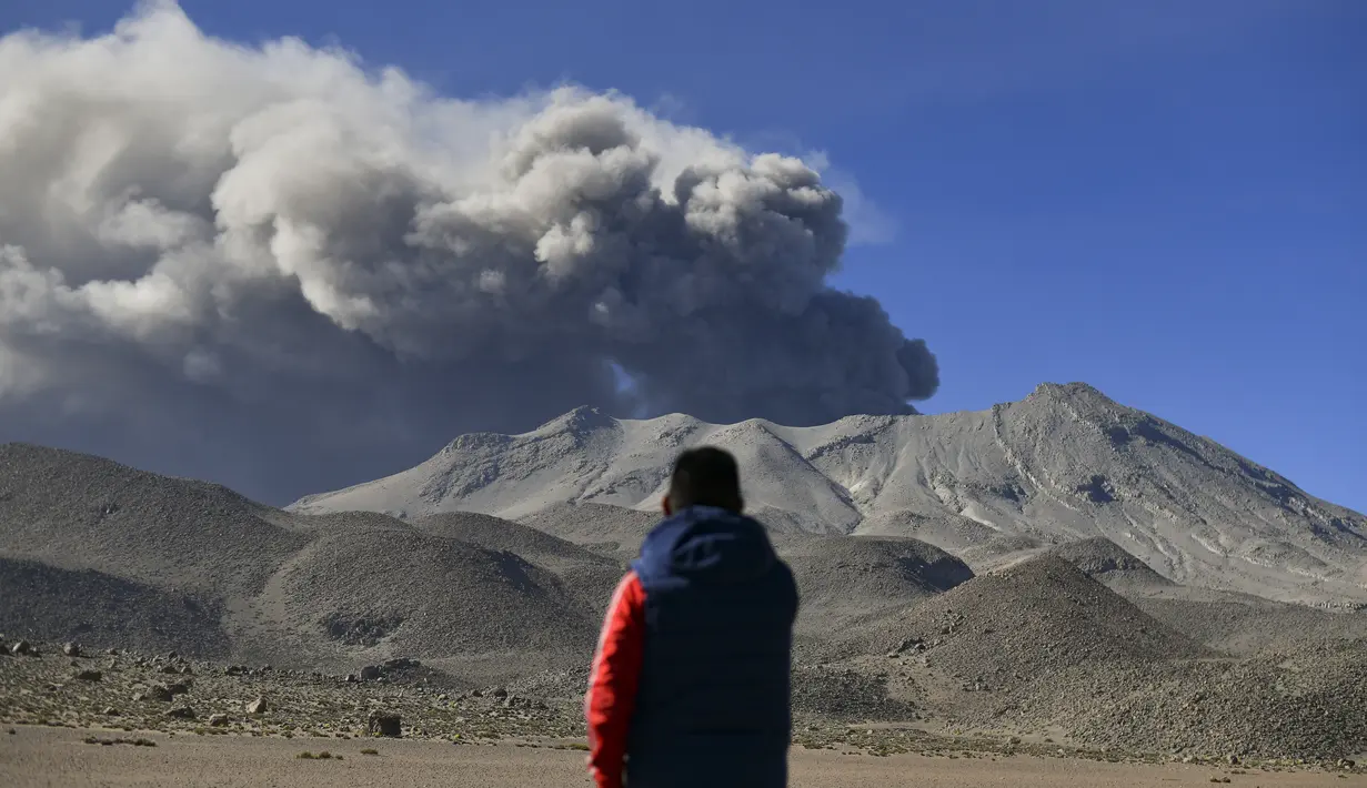 Seorang pria menyaksikan tumpukan asap dan abu naik dari kawah gunung berapi Ubinas, yang terletak di wilayah Moquegua di Peru selatan, pada 5 Juli 2023. (Diego Ramos / AFP)