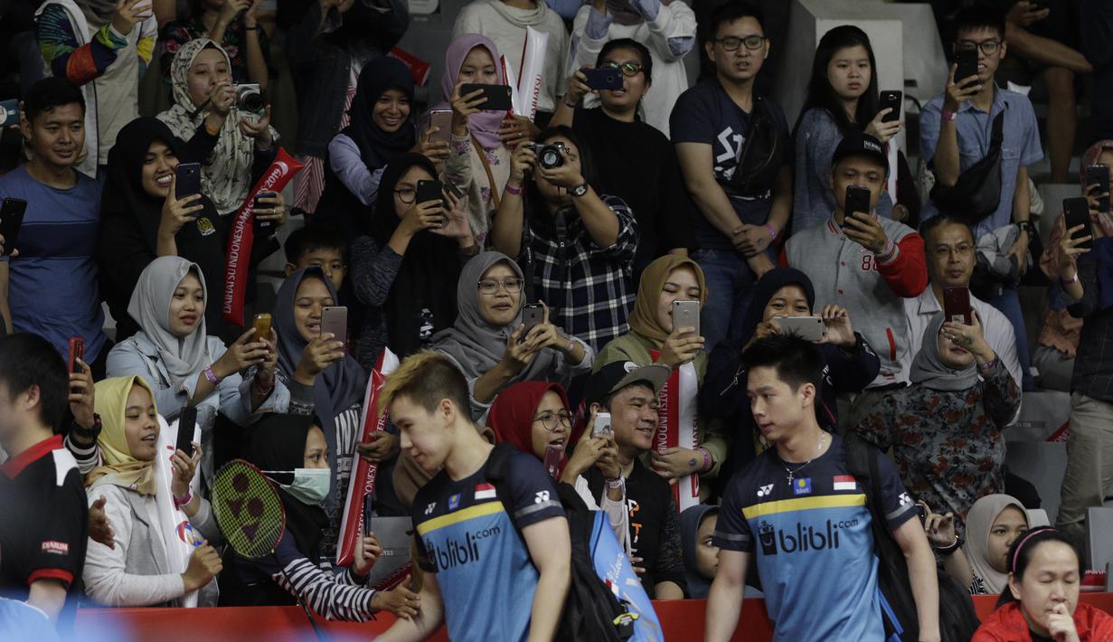 Suporter menyambut kedatangan ganda putra Indonesia, Kevin Sanjaya / Marcus Gideon, saat akan melawan ganda Jerman pada Indonesia Masters 2019 di Istora Senayan, Jakarta, Rabu (23/1). Kevin / Marcus lolos ke 16 besar. (Bola.com/M. Iqbal Ichsan)