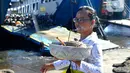 Umat Hindu Dharma membawa sesaji di depan dermaga kapal penyeberangan pada H-3 Lebaran Idul Fitri di Pelabuhan Gilimanuk, Bali, Rabu (19/4/2023). (merdeka.com/Arie Basuki)