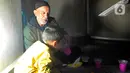 Seorang pengungsi menyuapi minuman kepada anaknya saat menikmati buka puasa bersama. (merdeka.com/Arie Basuki)