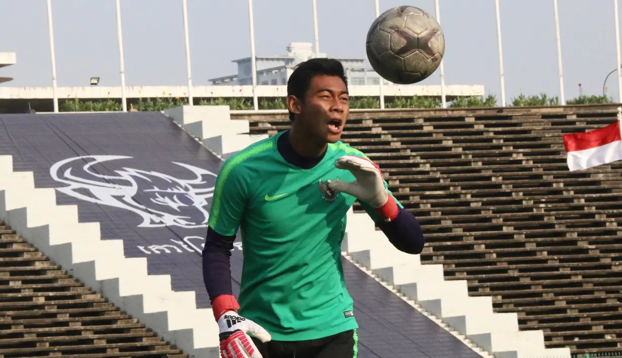 Kiper Timnas Indonesia U-22, Satria Tama, berusaha menyundul bola saat latihan di Stadion National Olympic, Phnom Penh, Sabtu (23/2). Latihan ini persiapan jelang laga semifinal Piala AFF U-22 melawan Vietnam. (Bola.com/Zulfirdaus Harahap)