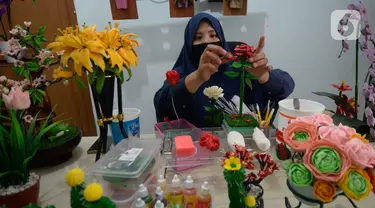 Perajin bunga sabun, Irniyuniati membuat bunga mawar dari sabun batangan yang sudah diolah di Perumahan Bukit Indah, Ciputat, Tangerang Selatan, Jumat (2/10/2020). Bunga-bunga yang terbuat dari bahan dasar sabun dijual dengan harga Rp35 ribu hingga Rp 700 ribu per biji. (merdeka.com/Dwi Narwoko)
