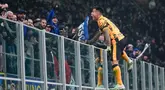 Pemain Inter Milan, Lautaro Martinez, melakukan selebrasi memanjat pagar setelah mencetak gol ke gawang Genoa dalam laga Serie A 2024/2025 giornata 26 nan dihelat di Giuseppe Meazza, Minggu (23/2/2025) awal hari WIB. (AP Photo/Luca Bruno)