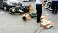 Seorang pemuda di Tiongkok tampak asyik menggunakan ponsel-nya di tengah jalan, sesaat setelah tertabrak sebuah mobil (Foto: via Daily Mail)