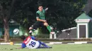 Pemain PS TNI, Erwin Ramdani melompat menghindari terangan pemain Uni Papua pada laga uji coba di Mako Kostrad, Cilodong, Jawa Barat, (14/7/2016). (Bola.com/Nicklas Hanoatubun)