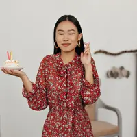 ilustrasi seorang perempuan memegang sepotong kue ulang tahun/copyright freepik.com/lookstudio