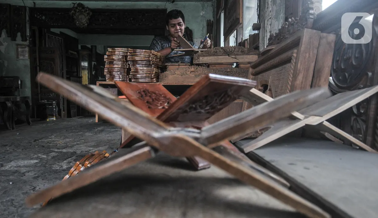 Pekerja menyelesaikan pembuatan rehal atau meja untuk Al-qur’an di Toko Mabruri 12, Klender, Jakarta, Rabu (13/4/2022). Penjualan rehal pada Ramadhan kali ini mengalami peningkatan hingga 50 persen dibandingkan tahun sebelumnya. (merdeka.com/Iqbal S Nugroho)