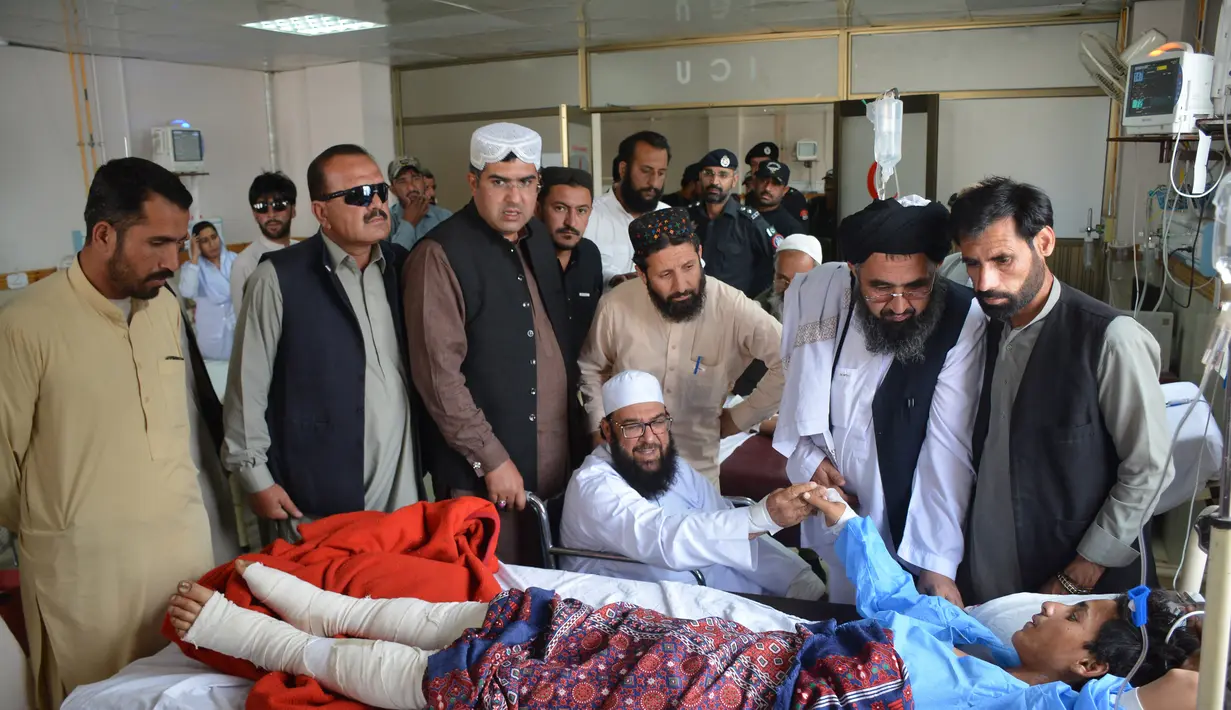 Wakil ketua Majelis Tinggi Parlemen Pakistan, Maulana Abdul Ghafoor Haideri (tengah) menyalami seorang korban ledakan bom bunuh diri di sebuah rumah sakit pemerintah di Quetta, Selasa (16/5). (AFP FOTO / BANARAS KHAN)