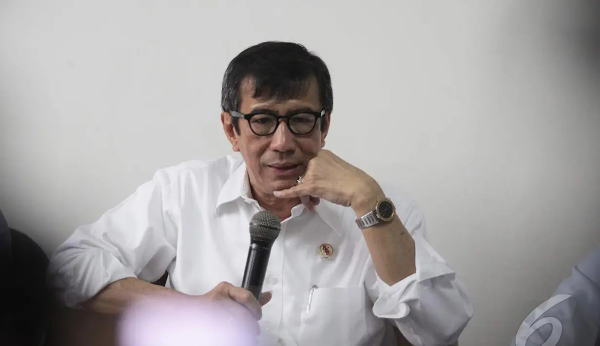 Menteri Hukum dan HAM Yasonna Laoly menyimak pertanyaan wartawan terkait dualisme kepimpinan Partai Golkar, Jakarta, Selasa (16/12/2014) (Liputan6.com/Faizal Fanani)