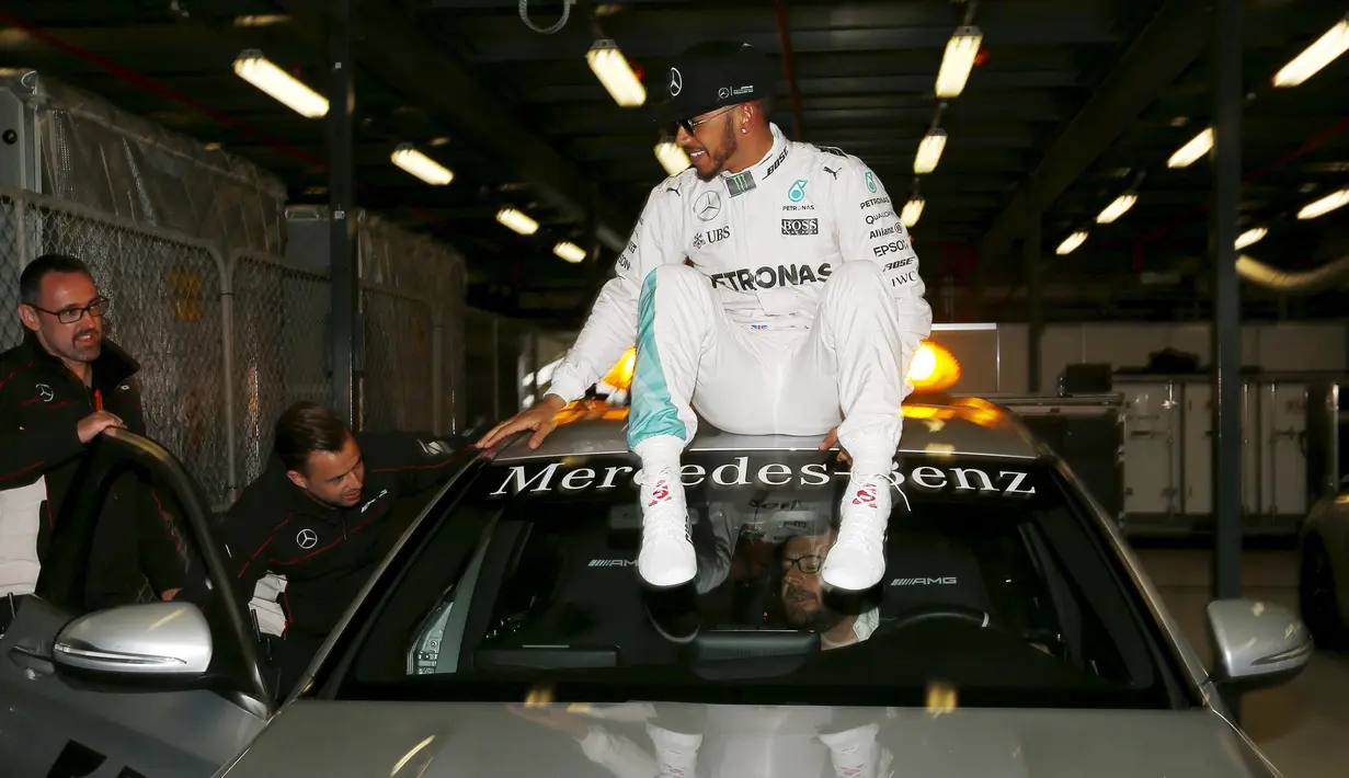 Pembalap Mercedes F1 Lewis Hamilton duduk di atas mobil menunggu konferensi pers setelah kualifikasi di Australian Formula One Grand Prix di Melbourne (19/3). Juara F1 musim lalu itu mencatatkan waktu 1 menit 23,837 detik. (REUTERS/Jason Reed)