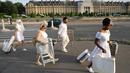 Sejumlah orang berpakaian putih membawa peralatan dan kursi untuk mengikuti makan malam bersama atau "Diner en Blanc" yang ke-30 di Paris, Prancis (3/6). (AFP/Francois Guillot)