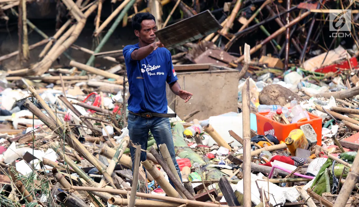 Pemulung mencari sisa barang yang masih bisa dimanfaatkan diantara tumpukan sampah di Pintu Air Manggarai, Jakarta, Jumat (26/4). Sampah ini terbawa arus sungai Ciliwung akibat curah hujan yang tinggi di kawasan Bogor dan sekitarnya, Kamis (25/4). (Liputan6.com/Helmi Fithriansyah)
