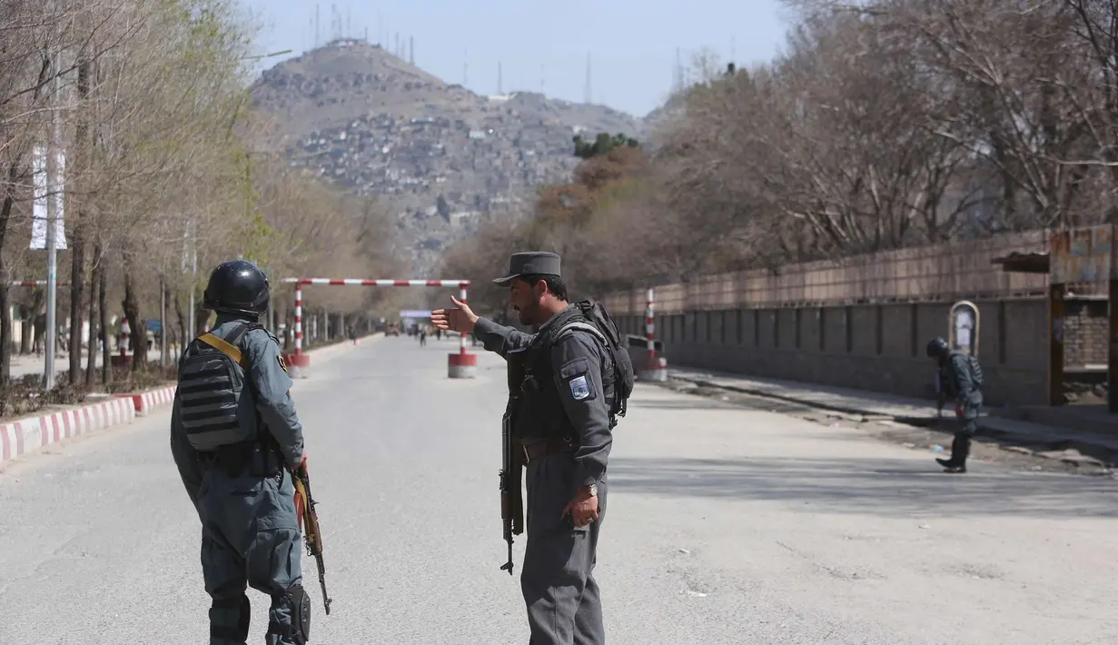 Polisi berpatroli di jalan-jalan setelah serangan bunuh diri di depan Universitas Kabul, Afghanistan, (21/3). Pejabat Afghanistan melaporkan ledakan tersebut di saat warga merayakan Tahun Baru Persia. (AP Photo/Rahmat Gul)