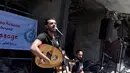 Penampilan seorang penyanyi Palestina selama acara musik di puing-puing bangunan yang baru-baru ini hancur oleh serangan udara Israel di kota Gaza, Selasa (14/5/2019). Aksi itu untuk menyerukan pemboikotan terhadap Kontes Lagu Eurovision 2019 yang diselenggarakan di Israel. (REUTERS/Mohammed Salem)