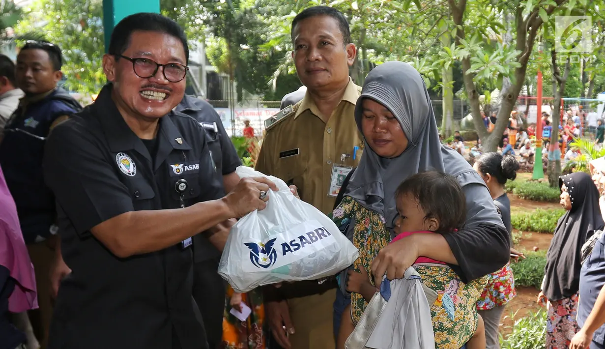 Sekretaris Perusahaan PT Asabri (Persero) Djoko Rachmadhy secara simbolis menyerahkan sembako murah di RPTRA Alur Dahlia, Tegal Alur, Jakarta Barat, Selasa (21/5/2019). PT Asabri (Persero) menjual sebanyak 3 ribu sembako seharga Rp 10 ribu kepada masyarakat sekitar. (Liputan6.com/Johan Tallo)
