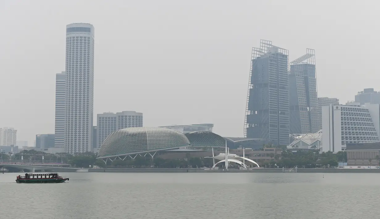 Deretan gedung yang diselimuti kabut asap di Marina Bay, Singapura (13/9/2019). Titik api di hutan hujan Indonesia telah melonjak tajam, data satelit menunjukkan pada 12 September, menyebarkan kabut asap di Asia Tenggara. (AFP Photo/Roslan Rahman)