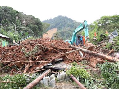 Gambar selebaran yang diambil pada 8 Maret 2023 dan dirilis pada 9 Maret 2023 oleh Badan Penanggulangan Bencana Indonesia ini menunjukkan tim SAR dan alat berat terlihat di lokasi tanah longsor di desa Pangkalan, Natuna, Kepulauan Riau (Kepri). Tim gabungan masih terus mencari puluhan korban hilang pasca tanah longsor yang menimbun satu kampung di Desa Pangkalan. (HO / INDONESIA DISASTER MITIGATION AG / AFP)