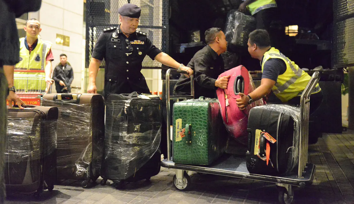 Polisi Malaysia memasukkan sejumlah koper berisi barang-barang yang disita dari tiga apartemen mantan Perdana Menteri Najib Razak di Kuala Lumpur, Jumat (18/5). Selain tas mewah, polisi juga menyita 72 tas bagasi berisi uang tunai dan perhiasan (AP Photo)
