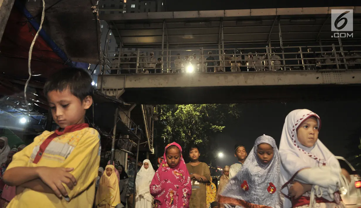 Sejumlah warga melaksanakan salat tarawih di atas Jembatan Penyebrangan Orang (JPO) Mushola Mifhtaul Jannah di Kawasan Pasar Gembrong, Jakarta, 5 Mei 2019. JPO yang biasa digunakan untuk akses menyeberang mendadak jadi area ibadah salat tarawih pada Ramadan 1440 H. (merdeka.com/Iqbal S. Nugroho)