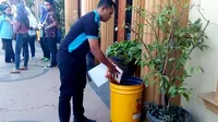 Sulaiman Sulang memungut sampah di sekolah yang akan disetor ke bank sampah (Zainul Arifin/Liputan6.com