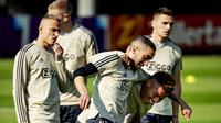 Pemain Ajax Amsterdam, Hakim Ziyech berebut bola dengan David Neres saat sesi latihan di Sports park De Toekomst, Belanda (9/4). Ajax akan bertanding melawan wakil Italia Juventus pada leg pertama babak perempatfinal Liga Champions di Johan Cruyff Arena. (AFP Photo/ANP/Robin van Lonkhuijsen)