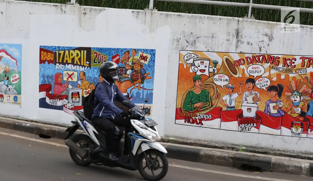 Pengendara motor melintasi mural bertema Pemilu 2019 di kawasan Dukuh Atas, Jakarta, Senin (1/4). Mural-mural tersebut dibuat dalam rangka menyukseskan Pemilu yang akan berlangsung pada 17 April 2019 mendatang. (Liputan6.com/Immanuel Antonius)