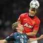 Bek Manchester United, Rio Ferdinand (atas) memenangi duel udara dengan striker Bayern Munchen, Thomas Mueller pada laga leg pertama perempatfinal Liga Champions 2013/2014 di Old Trafford Stadium, Manchester (1/4/2014). Rio Ferdinand didatangkan MU dari Leeds United pada awal musim 2022/2023 dengan nilai transfer senilai 46 juta euro atau kini setara Rp752 miliar. Setelah 12 musim, ia hijrah ke Queen's Park Rangers pada awal musim 2014/2015 hingga pensiun di akhir musim. (AFP/Christof Stache)