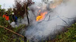 Dua anggota Taruna Siaga Bencana berupaya memadamkan api yang menjalar di lahan hutan, di kawasan Jalan Sepakat II, Pontianak, Kalbar, Senin (2/4). Berdasarkan pantauan Badan Lingkungan Hidup Daerah Kalbar, dalam sepekan ini terdapat 54 titik panas yang terjadi akibat pembakaran lahan di sejumlah kabupaten di wilayah Kalbar. (Antara)