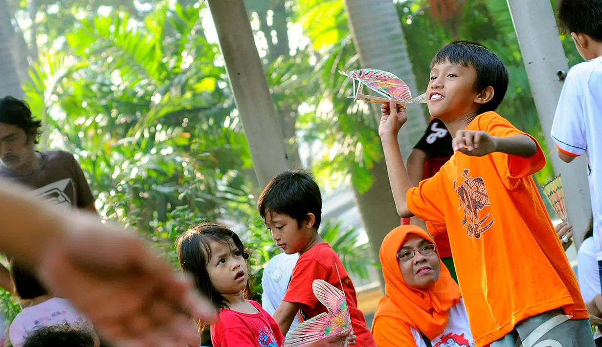 Aksi seorang bocah akan menerbangkan pesawat kayu di acara "Save   Our Children", Jakarta, Minggu (23/11/2014) (Liputan6.com/Faisal R   Syam)