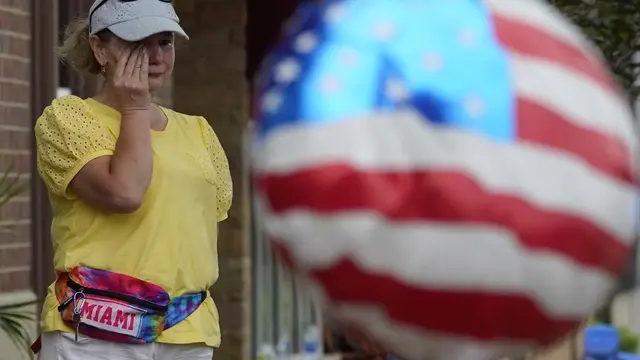 Seorang wanita menyeka air mata setelah penembakan massal di parade Highland Park Fourth of July di Highland Park, Illinois, pinggiran Chicago, Senin, 4 Juli 2022. (AP Photo/Nam Y. Huh)