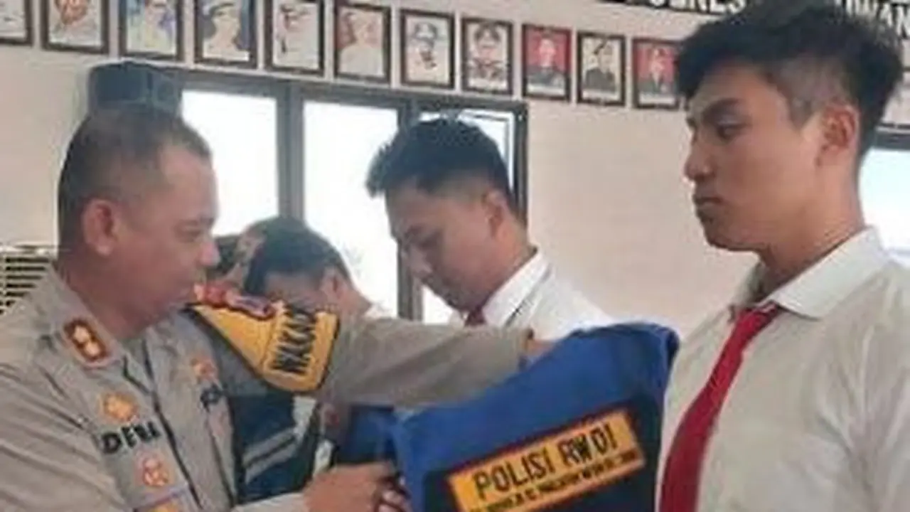 Wakapolresta Banyuwangi AKBP Dewa Putu Eka Darmawan pakaikan rombi polisi RW yang akan bertugas di Banyuwangi (Istimewa)