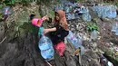Warga  mengambil air untuk minum dan kebutuhan mck rumah  di sumber mata air Sumur Bendung, Gunung Batur, Kota Cilegon, Banten, Minggu, (15/7/2026). (KLY/Arie Basuki)
