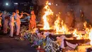 Seorang biksu menyalakan api untuk mengkremasi korban tewas dalam serangan pusat penitipan anak di Kuil Wat Rat Samakee, Uthai Sawan, Thailand, Selasa (11/10/2022). Ini adalah pembunuhan massal terbesar oleh seorang individu dalam sejarah Thailand. (AP Photo/Wason Wanichakorn)