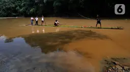 Sejumlah siswa menyeberangi Sungai Cikaniki dengan rakit di Rumpin, Bogor, Jawa Barat, Rabu (15/1/2020). Akibat banjir bandang merobohkan jembatan yang menghubungkan Desa Tonjong Rumpin dan Desa Kantalarang Leuwiliang, warga terpaksa memanfaatkan perahu rakit untuk melintas (merdeka.com/Arie Basuki)