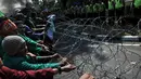 Sejumlah mahasiswa berusaha melewati kawat penghalang saat aksi hari Kebangkitan Nasional menuju Istana Presiden, Jakarta, Rabu (20/5/2015). Ribuan mahasiswa menuntut agar Jokowi - JK segera turun. (Liputan6.com/Johan Tallo)