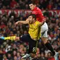 Bek Manchester United, Harry Maguire, berebut bola dengan bek Arsenal, Sokratis Papastathopoulos, pada laga Premier League di Stadion Old Trafford, Manchester, Senin (30/9). Kedua klub bermain imbang 1-1. (AFP/Paul Ellis)