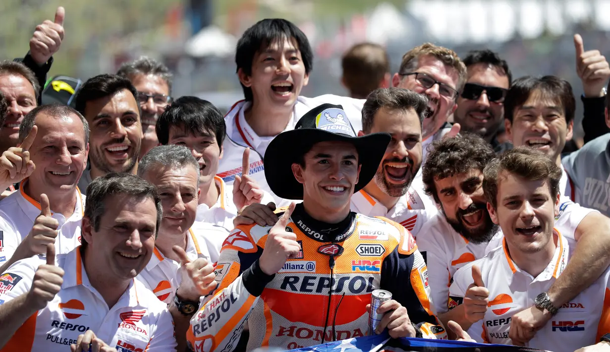 Pembalap Marc Marquez berpose bersama kru tim Repsol Honda seusai memenangi balapan MotoGP Amerika di Circuit of the Americas (COTA), Austin, Minggu (22/4). Marquez menjadi pemenang dengan dengan catatan waktu 41 menit 52.002 detik. (AP/Eric Gay)