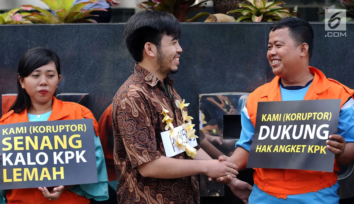 Aktivis memparodikan adegan peristiwa pertemuan anggota Pansus Hak Angket KPK dengan para narapidana kasus korupsi di depan Gedung KPK, Jakarta, Minggu (9/7). Mereka mengkritisi pertemuan tersebut. (Liputan6.com/Helmi Fithriansyah)