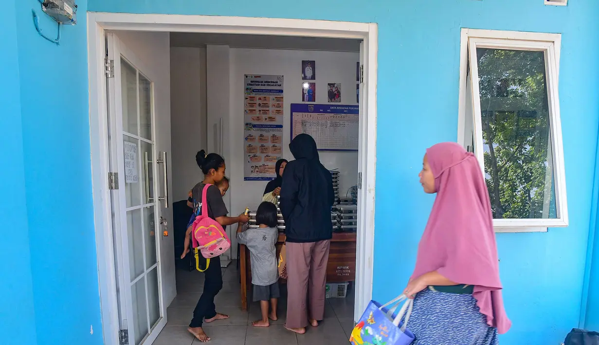 Ibu dan anaknya mengambil makan bergizi gratis (MBG) untuk dikonsumsi di rumah di Posyandu kawasan Limo, Depok, Jawa Barat, Selasa (14/7/2025).