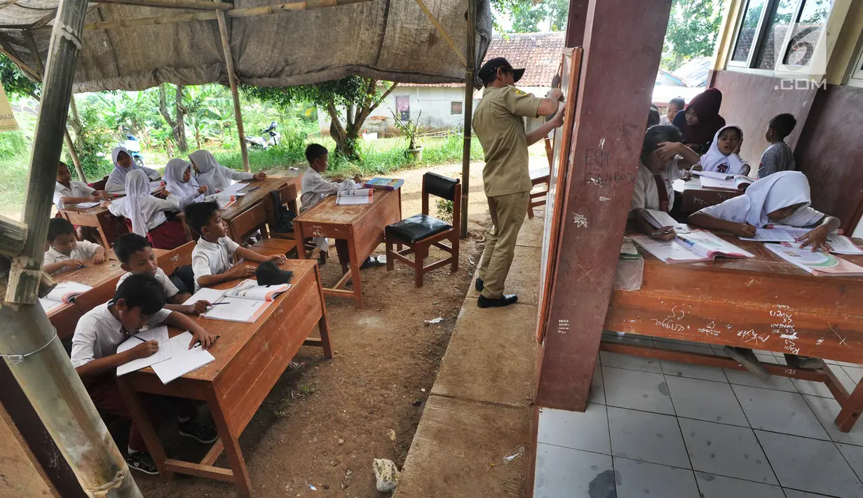 Sejumlah murid SDN Mutiara mengikuti aktivitas belajar di dalam tenda darurat di Kampung Pasir Bayur, Cibeber II, Bogor, Selasa (3/4). Di sekolah itu, hanya tersisa 2 ruangan yang dipergunakan bagi kelas 6 dan ruangan guru. (Merdeka.com/Arie Basuki)