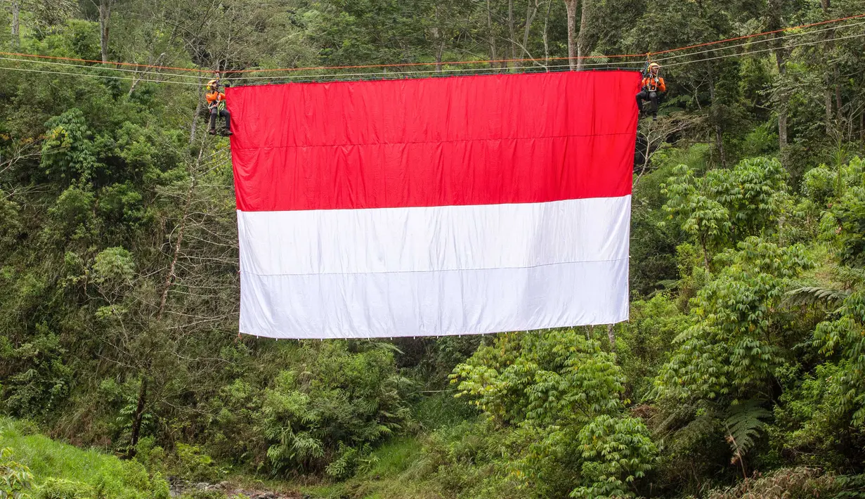 Upacara berlangsung khidmat yang ditandai dengan pengibaran bendera Merah Putih pada tali yang membentang di atas sungai di Watu Kemloso, Yogyakarta. (DEVI RAHMAN/AFP)