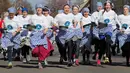 Para peserta melakukan pemanasan sebelum lomba lari dengan membawa pancake dalam lomba tahunan Pancake Trans-Atlantic, di kota Olney, Buckinghamshire, Inggris, Selasa (5/3). Peserta harus membolak-balikan pancake sambil tetap berlari. (AP/Frank Augstein)
