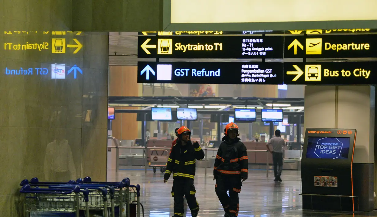 Petugas berada di bandara internasional Changi usai terjadi kebakaran kecil di salah satu terminal, Singapura, Selasa (16/5). Polisi mengatakan, alarm kebakaran terdengar pada pukul 17.40 saat asap muncul dari lubang-lubang ventilasi. (AFP/ TOH TING WEI)