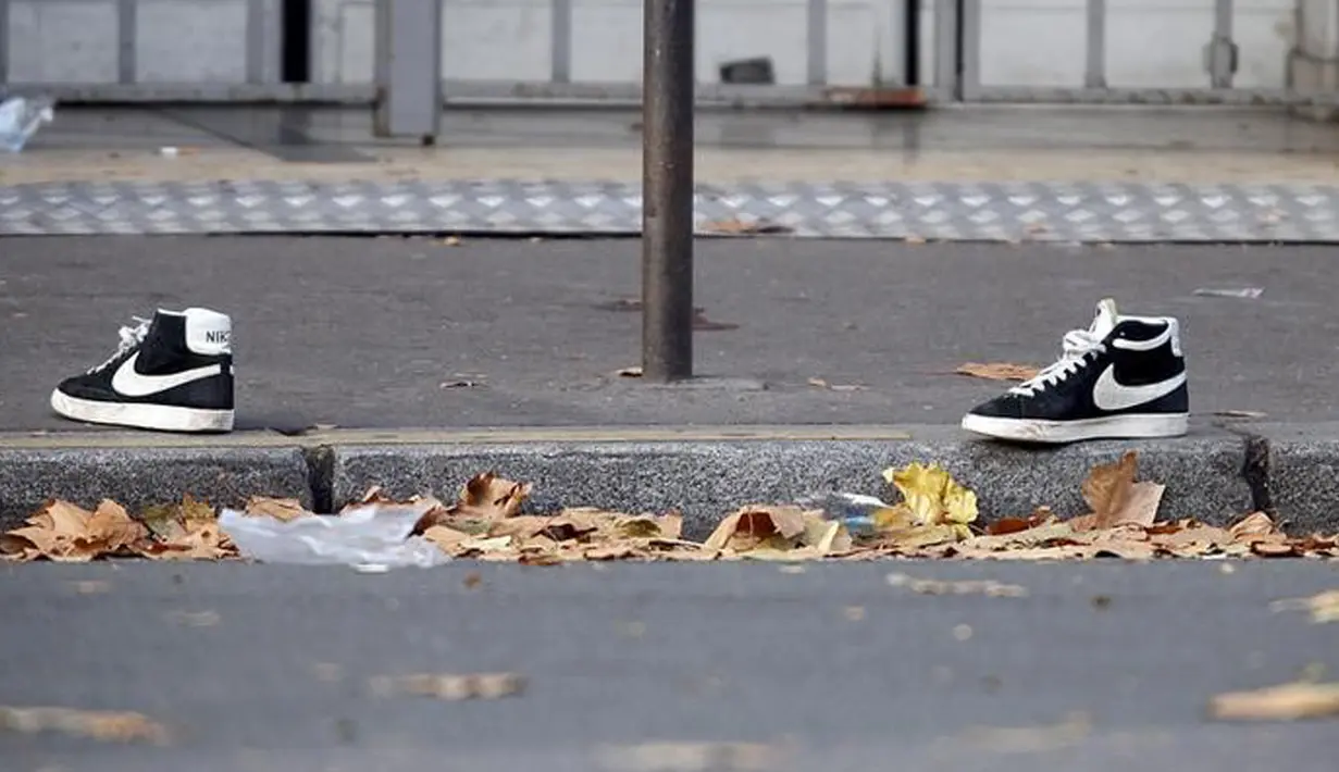 Sepasang sepatu yang tertinggal dipinggir jalan dimana tempat penembakan terjadi di Paris, Prancis, Sabtu (14/11/2015). Dikabarkan ratusan orang tewas dalam serangan ini. (REUTERS/Charles Platiau)