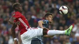 Aksi Paul Pogba (kiri) berebut bola dengan pemain Celta Vigo, Nemanja Radoja pada semifinal Liga Europa di Old Trafford, Manchester (11/5/2017). Manchester United menang agregat 2-1. (AP/Dave Thompson)