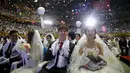 Sejumlah pasangan saat mengikuti pernikahan massal di Gereja Unifikasi Korea Selatan, (20/02). Pernikahan massal di Korea Selatan sudah sering diadakan dan menjadi ciri khas gereja yang didirikan pada tahun 1954 tersebut.(REUTERS / Kim Hong - Ji)