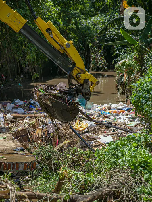 Petugas UPK Badan Air DLH Provinsi DKI Jakarta dibantu alat berat memperbaiki tembok Kali Krukut yang jebol di Jalan Taman Kemang, Jakarta, Selasa (23/2/2021). Jebolnya tembok tersebut mengakibatkan kawasan kemang dan sekitarnya terendam banjir pada 20 Februari 2021. (Liputan6.com/Faizal Fanani)